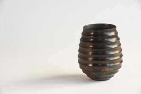 Hollowed wooden vessel with natural grain showing beneath fire-blackened finish.